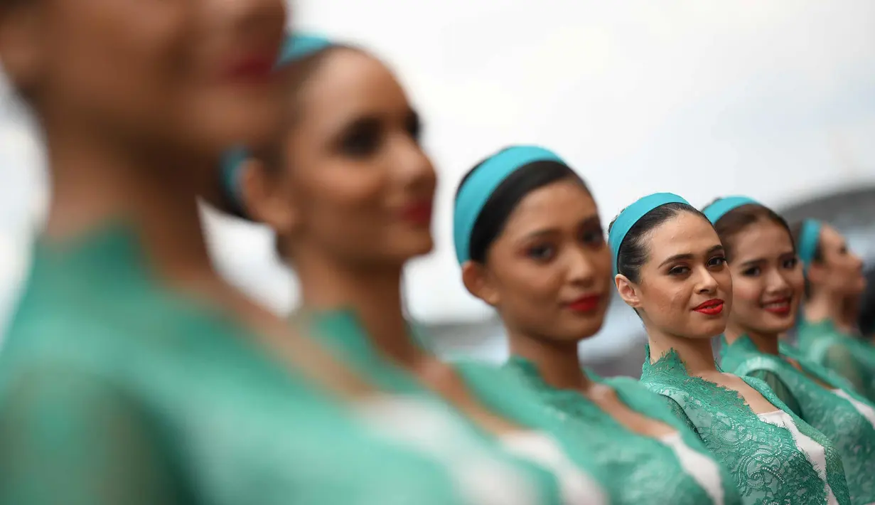 Seorang gadis payung atau grid girl berpose sebelum dimulainya Grand Prix Formula 1 Malaysia di Sepang (1/10). Para gadis payung ini terlihat cantik dan seksi dengan busana yang dikenakannnya. (AFP Photo/Manan Vatsyayana)