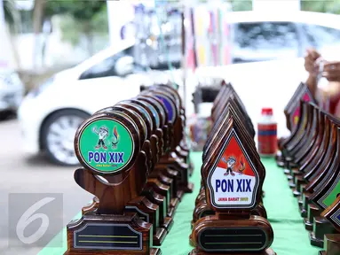 Plakat berhias logo PON XIX Jabar dipajang di salah satu stand UMKM di GOR Universitas Pendidikan Indonesia, Senin (19/9). Beberapa pedagang memanfaatkan moment PON XIX Jabar untuk menjual beragam pernak pernik. (Liputan6.com/Helmi Fithriansyah)