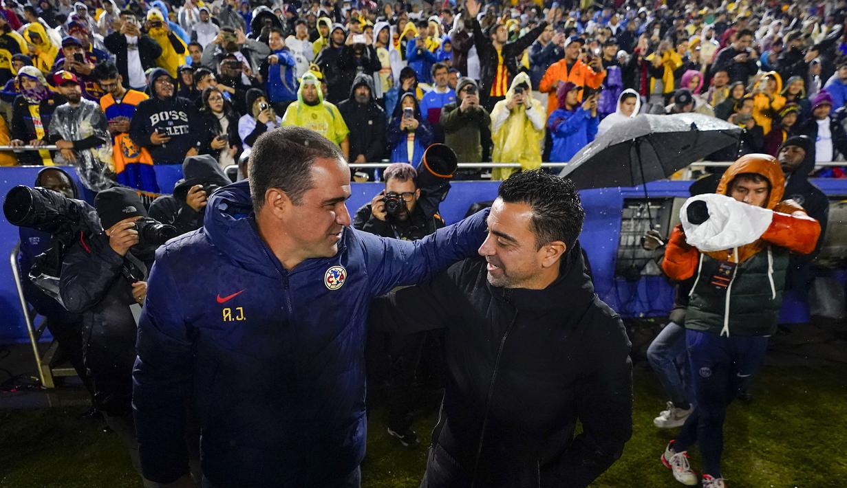Pelatih Barcelona, Xavi Hernandez (kanan) saling berangkulan dengan pelatih Club America, Andre Jardine pada laga persahabatan di Cotton Bowl, Dallas, Amerika Serikat, Jumat (22/12/2023) dini hari WIB. (AP Photo/Julio Cortez)