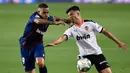 Bek Valencia, Hugo Guillamon, berebut bola dengan penyerang Levante, Roger Marti, pada laga pekan ke-28 Liga Spanyol di Stadion Mestalla, Sabtu (13/6/2020) dini hari WIB. Valencia bermain imbang 1-1 atas Levante. (AFP/Jose Jordan)