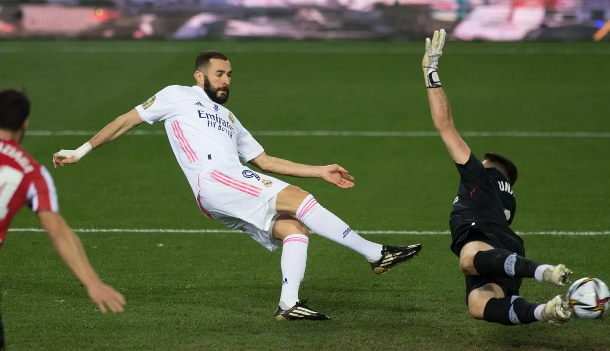 Striker Real Madrid, Karim Benzema (tengah) melepaskan tendangan yang berbuah gol untuk timnya ke gawang Athletic Bilbao dalam laga semifinal Piala Super Spanyol 2020/21 di La Rosaleda Stadium, Malaga, Kamis (14/1/2021). Real Madrid kalah 1-2 dari Athletic Bilbao. (AFP/Jorge Guerrero)