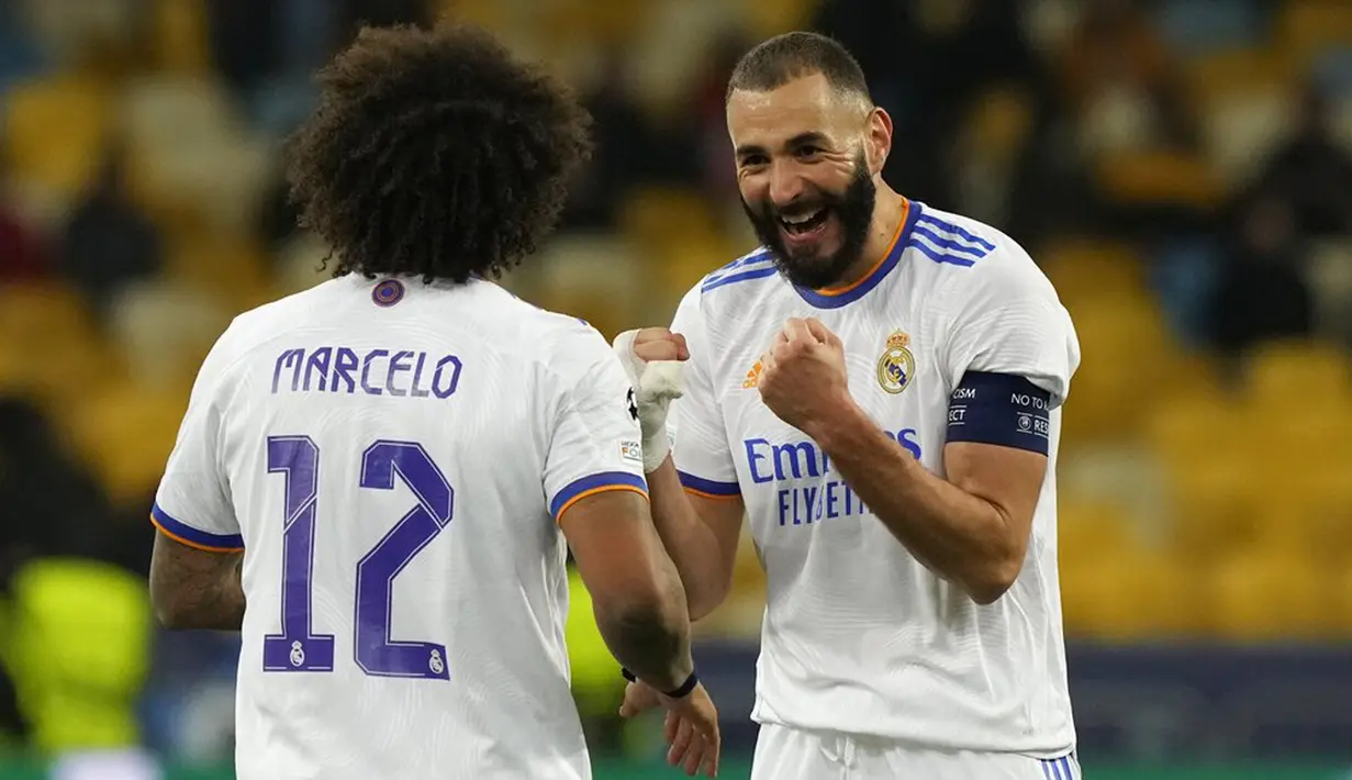 Pemain Real Madrid Karim Benzema (kanan) melakukan selebrasi usai mencetak gol ke gawang Shakhtar Donetsk pada pertandingan grup D Liga Champions di Stadion Olympiyskiy, Kyiv, Ukraina, Selasa (19/10/2021). Real Madrid menang 5-0. (AP Photo/Efrem Lukatsky)
