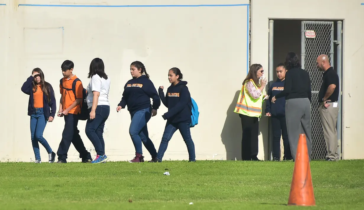 Para siswa dipulangkan setelah insiden penembakan oleh gadis 12 tahun di sekolah menengah Salvador Castro, Los Angeles, Kamis (1/2). Penembakan ini membuat panik orangtua siswa dan langsung datang dan berkumpul di sekitar sekolah. (Frederic J. Brown/AFP)
