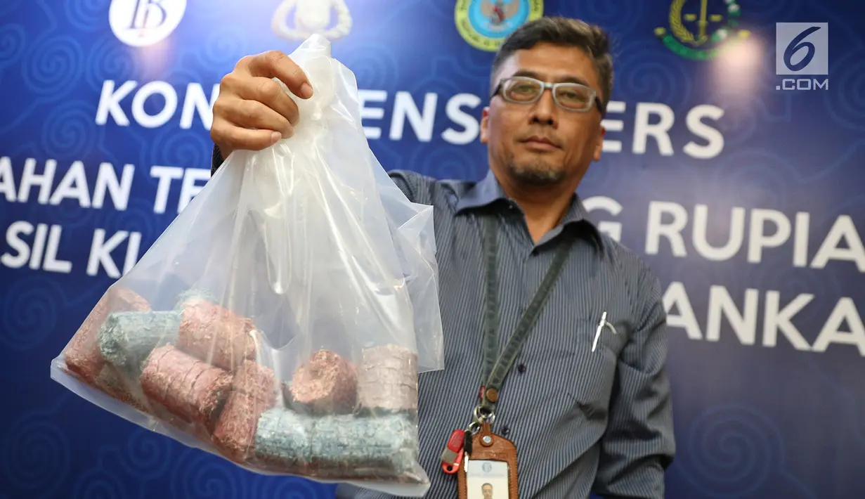 Petugas menunjukkan kantong plastik berisi residu atau sisa uang palsu yang sudah dihancurkan di Gedung Bank Indonesia (BI), Rabu (26/7). BI memusnahkan 189.477 uang rupiah palsu yang ditemukan sejak 2014 hingga akhir 2016 (Liputan6.com/Immanuel Antonius)