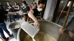 Sejumlah wanita mencampur olahan gandum saat membuat bir di tempat pembuatan bir di Black Pond Brews, Danielson (4/3). Mereka berkumpul sambil membuat bir untuk merayakan Hari Perempuan Internasional. (AP Photo / Steven Senne)