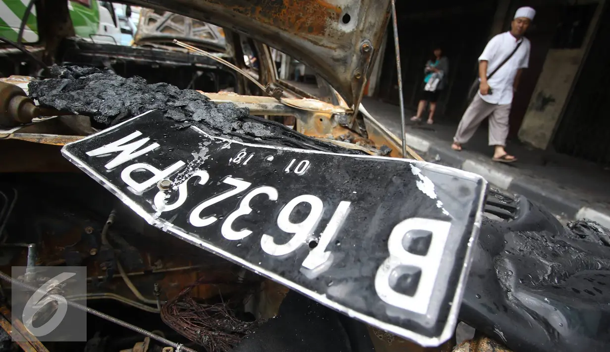 Plat nomor yang berada diatas bangkai mobil yang hangus akibat terbakar di Pecenongan, Jakarta, Sabtu (11/2). Berdasarkan saksi mata yang berada di seberang jalan lokasi, ia melihat ada dua motor berboncengan empat orang. (Liputan6.com/Immanuel Antonius)