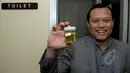 Anggota F-PKS Adang Daradjatun menunjukan wadah berisi urine usai mengikuti test di Komplek Parlemen Senayan, Jakarta, Kamis (26/3/2015). (Liputan6.com/Andrian M Tunay)