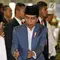 Presiden Joko Widodo atau Jokowi menyalami jemaah salat id saat tiba di Masjid Istiqlal, Jakarta, Rabu (5/6/2019). Jokowi mengenakan setelan jas abu-abu, kemeja putih serta peci hitam. (Liputan6.com/JohanTallo)