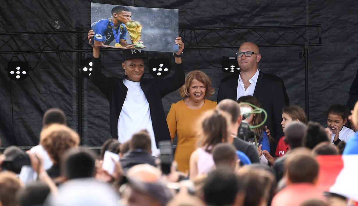 Bintang Prancis, Kylian Mbappe, menyapa fans saat mengunjungi markas AS Bondy di Paris, Rabu (17/10). Kunjungan ke klub pertamanya ini dilakukan setelah dirinya meraih gelar Piala Dunia 2018. (AFP/Anne-Christine Poujoulat)