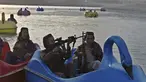 Sejumlah pasukan Taliban saat menaiki perahu kayuh di Danau Qargha di sebuah pekan raya di Kabul barat (28/9/2021). Sambil membawa senjata laras panjang sambil berjaga, mereka mengayuh perahu bebek memutari danau. (AFP/Wakil Kohsar)