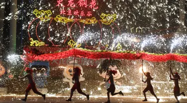 Penari melakukan tarian naga di sebuah taman pada hari keempat Tahun Baru Imlek di Beijing (8/2). China menandai kedatangan Tahun Babi dengan liburan Festival Musim Semi selama seminggu.  (AFP Photo/Greg Baker)