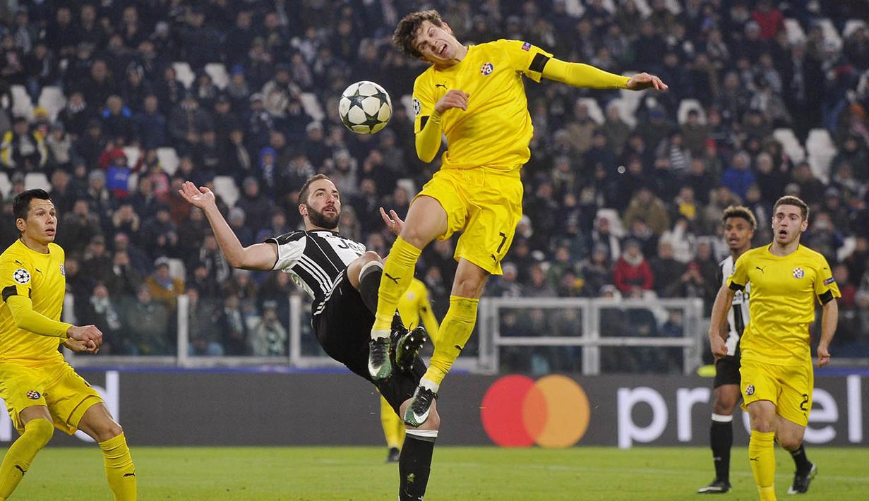 Penyerang Juventus, Gonzalo Higuain, duel udara dengan pemain Dinamo Zagreb, Mario Situm. Pada laga ini Juve melepaskan tujuh kali tembakan ke arah gawang, sementara Dinamo Zagreb hanya dua kali. (Reuters/Giorgio Perottino)