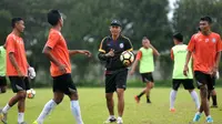 Pelatih Arema FC, Joko Susilo (topi), tengah memimpin latihan. (Bola.com/Iwan Setiawan)