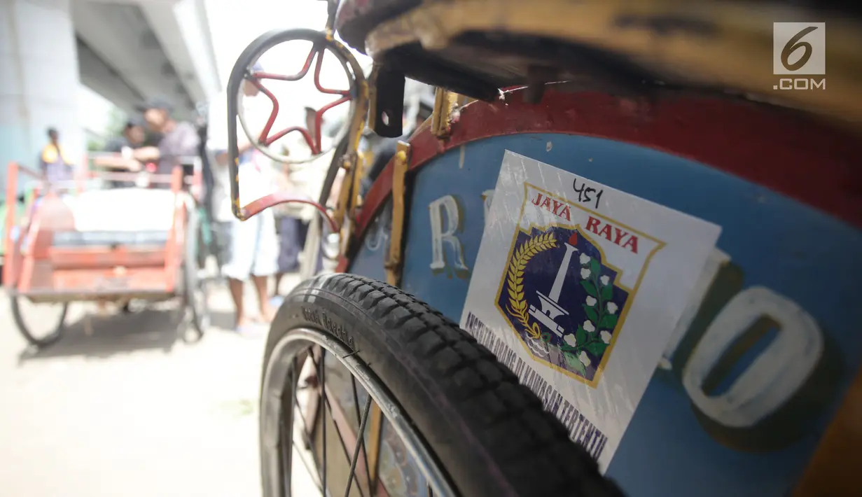 Stiker berlogo Pemprov DKI tertempel di salah satu becak seusai pendataan oleh petugas di Kolong Flyover Bandengan Utara, Jakarta, Kamis (25/1). Selain pendataan, pihaknya juga melakukan sosialisasi terhadap para tukang becak. (Liputan6.com/Arya Manggala)