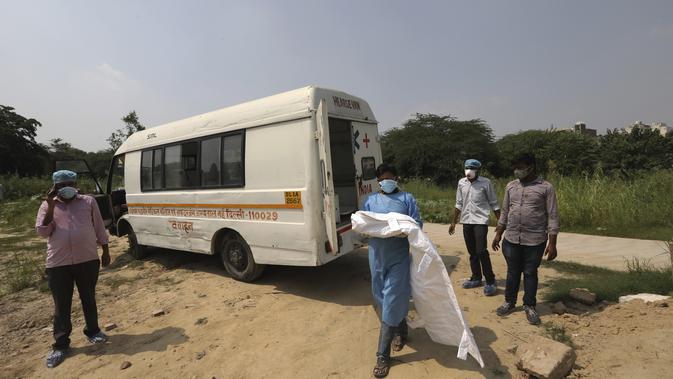 Seorang pria yang mengenakan pakaian pelindung diri menggendong tubuh putranya yang berusia tiga bulan yang meninggal karena COVID-19 di New Delhi, India, Rabu (16/9/2020). (AP Photo/Manish Swarup)
