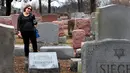 Sally Amon, melihat batu nisan neneknya yang dirusak di Chesed Shel Emeth Cemetery di University City, St Louis, Missouri, (21/2). Setidaknya lebih dari 100 batu nisan rusak di pekuburan itu. (Robert Cohen /St. Louis Post-Dispatch via AP)