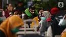 Calon penumpang menunggu keberangkatan kereta di Stasiun Senen, Jakarta, Jumat (25/12/2020). Petugas KAI yang mengenakan kostum Natal membagikan masker kepada calon penumpang untuk memutus mata rantai penyebaran COVID-19 saat mudik Natal dan Tahun Baru 2021. (merdeka.com/Imam Buhori)