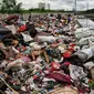 Warga membawa sampah sisa banjir yang dikumpulkan dari sepanjang Kali Cengkareng, Jakarta Barat, Kamis (9/1/2020). Tumpukan sampah di sepanjang bantaran kali dan rumah-rumah warga terlihat setelah banjir yang melanda sejumlah kawasan Jakarta mulai surut. (Liputan6.com/Johan Tallo)