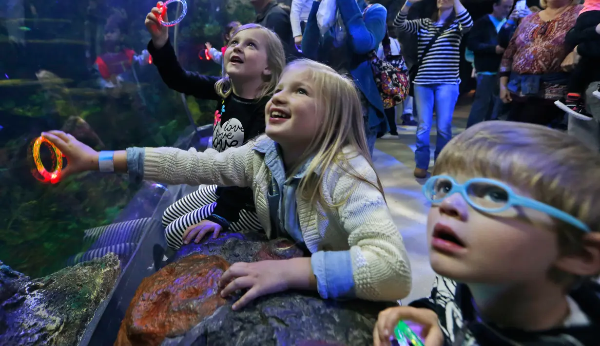 Ekspresi anak-anak saat menyaksikan atraksi putri duyung di Virginia Aquarium di Virginia Beach (3/4). Aquarium ini menyajikan atraksi putri duyung setiap minggunya selama bulan April. (AP Photo/Steve Helber)