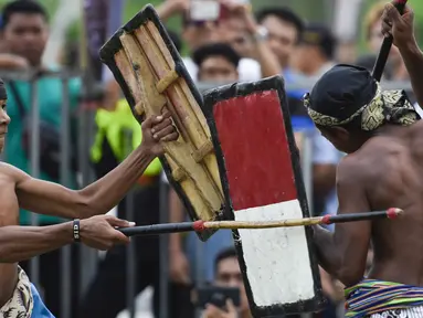 Dua pepadu (petarung) melakukan duel dalam kesenian tradisional peresean di Praya, Lombok Tengah, Selasa (19/2). Peresean merupakan kesenian tradisional suku Sasak yang dulunya diadakan setiap musim kemarau panjang. (MOH EL SASAKY/AFP)