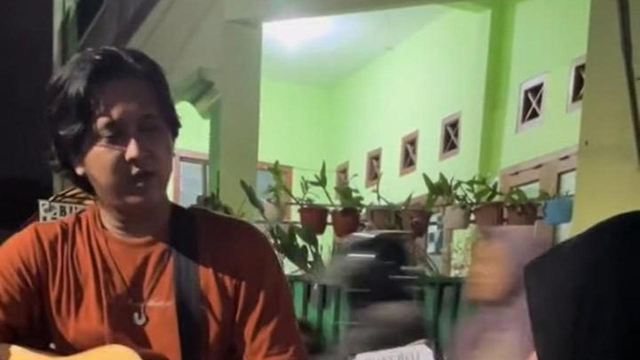 Pengamen ini pun tampak menyanyikan sebuah lagu di depan anak muda yang sedang berkumpul ini.