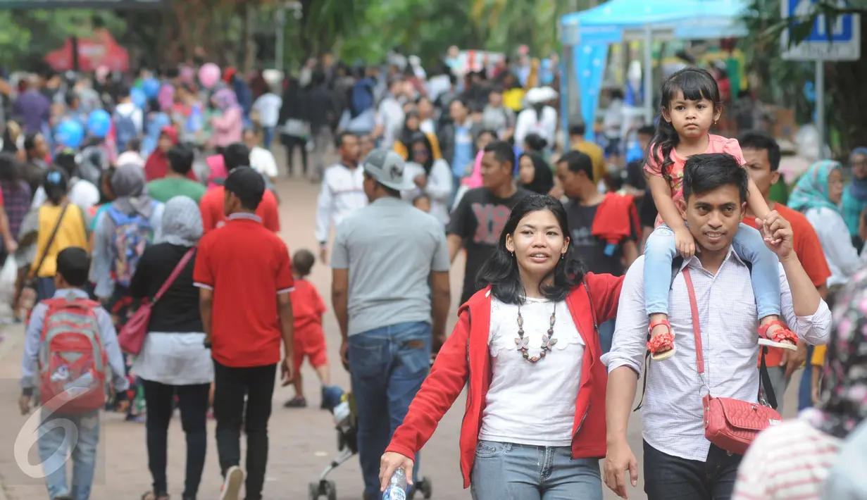 Seorang pengunjung menggendong anaknya saat berkunjung ke Ragunan, Jakarta, Minggu (25/12). Libur Natal dimanfaatkan warga untuk rekreasi bersama keluarga ke Ragunan. (Liputan6.com/Helmi Afandi)