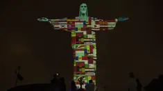Patung Christ the Redeemer bermandi cahaya bendera negara-negara yang saat ini terpapar virus corona COVID-19 di Rio de Janeiro, Brasil, Rabu (18/3/2020). Pertunjukan ini untuk menunjukkan dukungan bagi mereka yang menderita virus corona COVID-19. (AP Photo/Silvia Izquierdo)