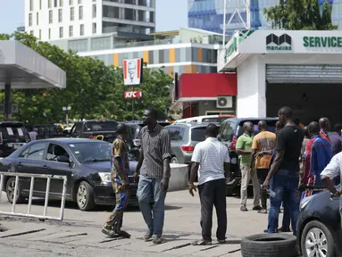 Orang-orang mengantre untuk membeli bahan bakar di SPBU Nigerian National Petroleum Company Limited di Lagos, Nigeria, Selasa (30/5/2023). (AP Photo/Sunday Alamba)