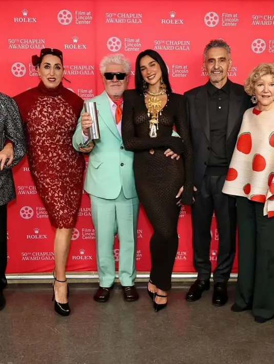 Ia juga nampak mengenakan sepasang anting emas, tas hitam dan sepatu hak Mary Jane [@dualipa]