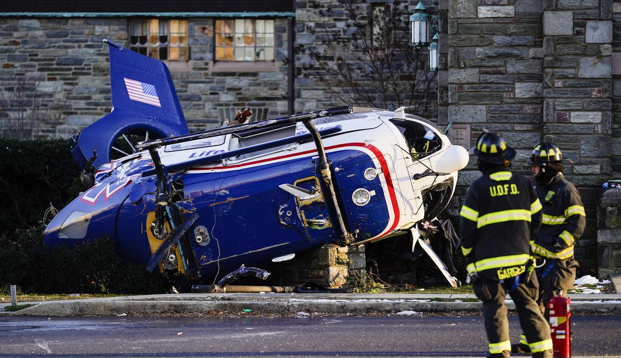Sebuah helikopter medis yang jatuh di dekat Gereja Drexel Hill United Methodist Church di Drexel Hill, Philadelphia, Pennsylvania, AS (11/1/2022). Helikopter medis yang akan menuju keluar negara AS terjatuh di dekat gereja. (AP Photo/Matt Rourke)