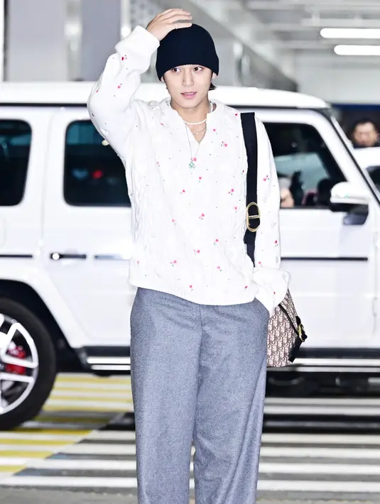 Melengkapi tampilannya dengan beanie hitam dan kalung putih dan kalung silver panjang berliontin.  [Dok. Dior]