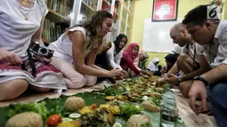 Sejumlah anak yatim, kaum dhuafa bersama lima warga negara asing (WNA) menikmati makanan nasi liwet sambil lesehan di Rumah Amalia, Ciledug, Kota Tangerang, Sabtu (3/3). Mereka juga berbagi cerita dan pengalaman di negaranya. (Liputan6.com/Fery Pradolo)