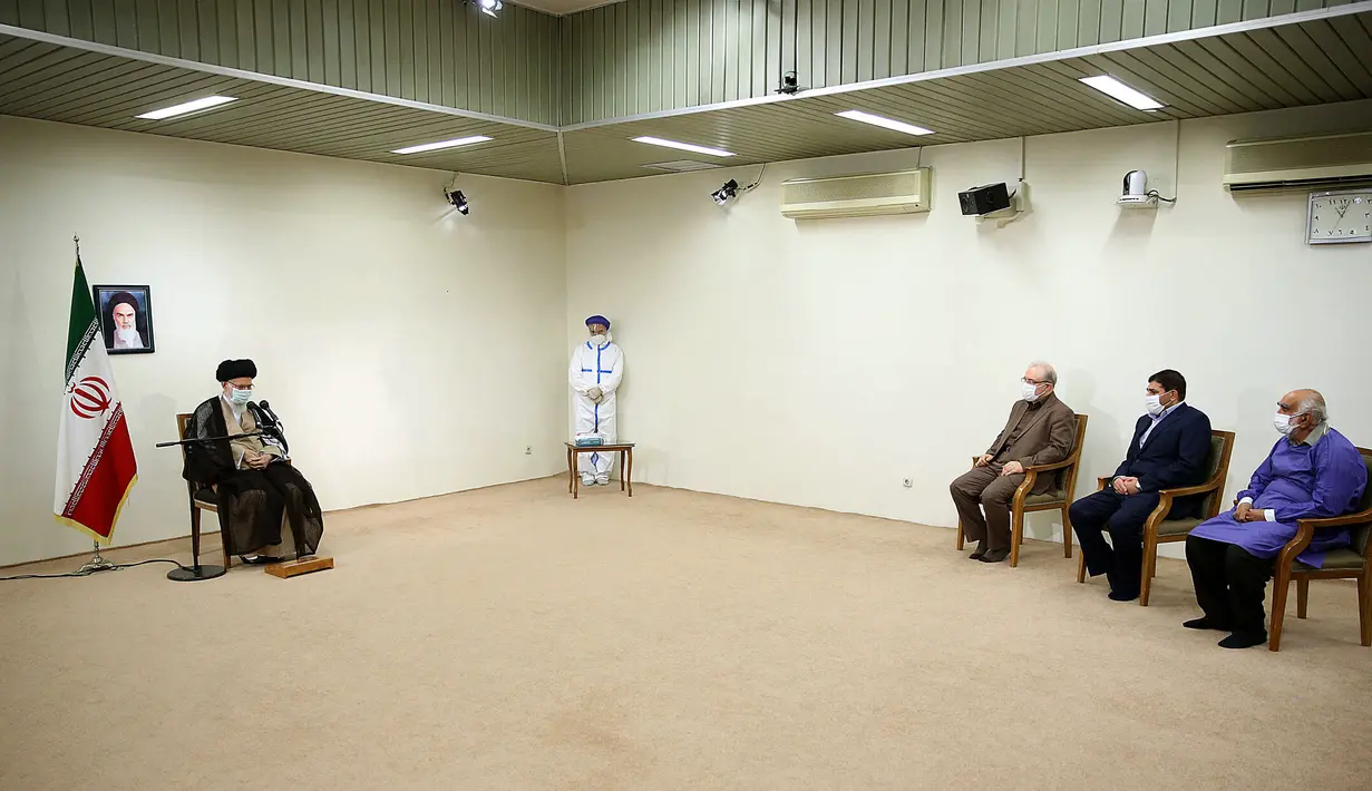 Pemimpin tertinggi Iran, Ayatollah Ali Khamenei berbincang dengan Menteri Kesehatan Iran Saeed Namaki (ketiga kanan) dan pejabat lainnya sebelum menerima dosis vaksin Covid-19 buatan lokal, COV-Iran Barekat, di Teheran, Jumat (25/6/2021). (KHAMENEI.IR / AFP)