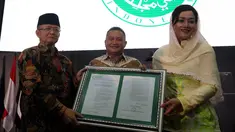 Dirut PT Kustodian Sentral Efek Indonesia (KSEI), Friderica Widyasari Dewi menerima salinan fatwa secara simbolis dari Sekretaris DSN-MUI, Anwar Abbas di Gedung BEI, Senin (1/4). KSEI secara resmi memperoleh fatwa dari DSN-MUI terkait Proses Bisnis Atas Layanan Jasa (Liputan6.com/Johan Tallo)