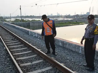 Petugas dari Polsuska dan Babinkamtibmas Kemijen Semarang  melakukan pemeriksaan rel kereta api di Jalur Kemijen, Minggu (3/6) . Pemeriksaan dilakukan secara ketat dan berkala untuk keamanan jalur kereta api selama arus mudik 2018. (Liputan6.com/Gholib)
