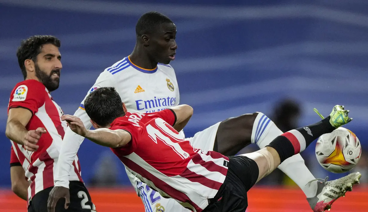 Bek Real Madrid, Ferland Mendy berebut bola dengan pemain Athletic Bilbao, Oier Zarraga dan Alex Petxarroman pada pertandingan lanjutan La Liga Spanyol di Santiago Bernabeu di Madrid, Spanyol, Kamis (2/12/2021). Real Madrid menang tipis atas Atletico Bilbao 1-0. (AP Photo/Bernat Armangue)