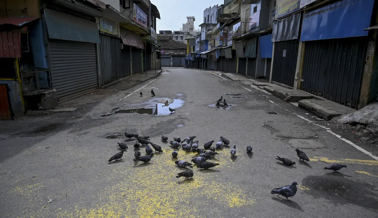 Kawanan merpati terlihat di jalan yang sepi setelah pemerintah memberlakukan pembatasan perjalanan dan lockdown akhir pekan di Kolombo, Sri Lanka, Sabtu (22/5/2021). Sri Lanka pada Jumat, 21 Mei mencatat 3.547 kasus harian corona Covid-19. (Ishara S. KODIKARA/AFP)