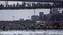 Para peserta mengambil bagian dalam Nautic Paddle Race di Paris, Minggu (9/12). Sekitar 800 orang mengikuti lomba dayung sambil berdiri terbesar di dunia sejauh 11 km menyeberangi sungai Seine. (Lucas BARIOULET/AFP)