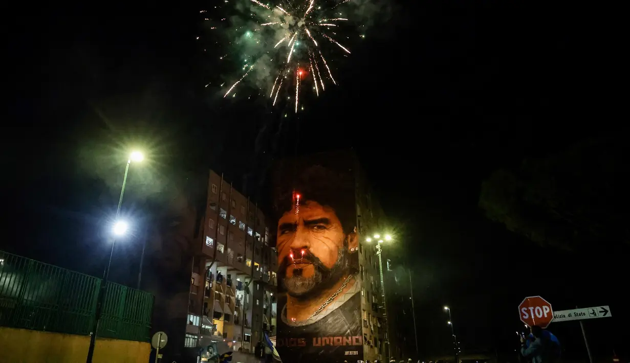 Fans merayakan ulang tahun Diego Maradona dengan kembang api di bawah mural legenda sepak bola itu di Distrik San Giovanni, Napoli, Italia, 30 Oktober 2022. Legenda sepak bola asal Argentina, Diego Armando Maradona yang lahir pada 30 Oktober 1960 meninggal pada 25 November 2020. (Alessandro Garofalo/LaPresse via AP)