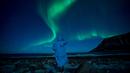 Seseorang menonton fenomena alam Aurora Borealis atau Northern Lights di Unstad, lingkaran Arktik, Norwegia, Sabtu (3/3). Aurora menampilkan banyak warna, tapi yang sering muncul adalah hijau muda dan pink. (Olivier MORIN/AFP)