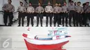 Miniatur kapal yang dibawa nelayan diletakan di dekat sejumlah aparat kepolisian yang berjaga di halaman PTTUN, Jakarta, Selasa (30/8). Para nelayan meminta hakim PTTUN menolak banding penerbitan izin reklamasi pulau G. (Liputan6.com/Immanuel Antonius)