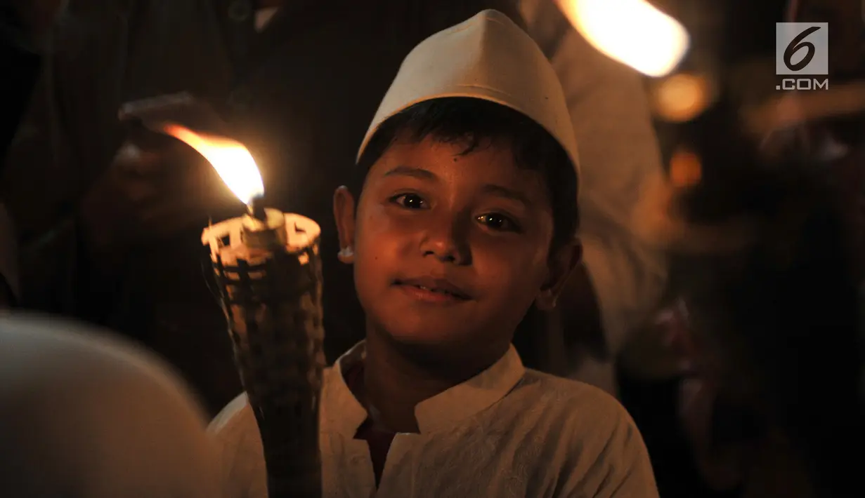 Seorang anak membawa obor saat pawai Tahun Baru Islam 1440 H di Menteng, Jakarta, Senin (10/9). Pawai obor yang diiringi musik bernuansa Islam merupakan tradisi umat muslim di Indonesia menyambut Tahun Baru 1 Muharram. (Merdeka.com/Iqbal S Nugroho)
