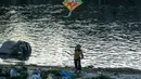 Seorang anak menerbangkan layang-layang di tepi sungai menjelang festival Hindu Dashain di Kathmandu (7/10/2020). Festival ini yang paling dinantikan di Nepal, Bhutan, Burma, dan perbukitan India Utara. (AFP/Prakash Mathema)