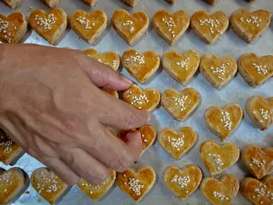 Pembuat kue kering menyelesaikan pembuatan kue pesanan di kawasan Neglasari, Kota Tangerang, Minggu (23/4/2022). Permintaan kue kering di tempat tersebut meningkat saat Ramadhan yang dijual mulai harga Rp50ribu hingga Rp70ribu per toples dan sudah dipasarkan di sekitar Tangerang, Jakarta, hingga Lampung. (Liputan6.com/Angga Yuniar)