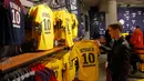 Suporter PSG melihat jersey penyerang Neymar Jr di toko Paris Saint Germain di Paris (4/8). PSG resmi membeli Neymar dari Barcelona setelah menebus klausul pelepasan kontrak senilai 222 juta Euro, atau sekitar Rp 3,5 triliun. (AP Photo/Michel Euler)