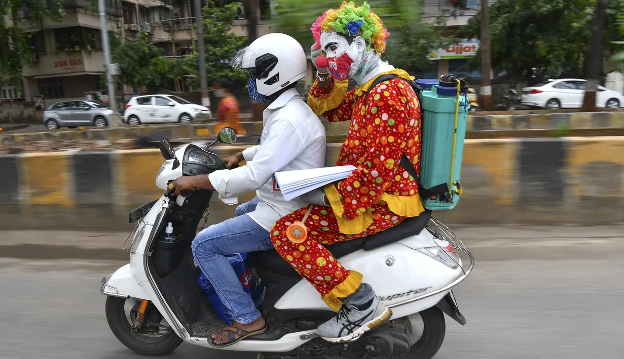 Relawan pekerja sosial, Ashok Kurmi dalam perjalanan untuk mendisinfeksi ruang publik di daerah kumuh Mumbai pada 2 Juni 2021. Kurmi turun tangan memerangi virus Corona COVID-19 di daerah kumuh Mumbai menggunakan aksesori yang tidak biasa, yaitu kostum badut. (INDRANIL MUKHERJEE/AFP)