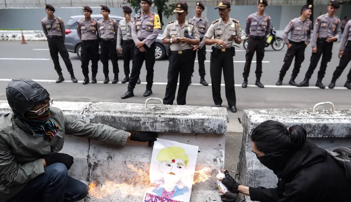 Petugas berjaga saat unjuk rasa penolakan kebijakan Presiden AS Donald Trump di depan kantor Kedubes AS di Jakarta Sabtu (4/2). Munculnya kebijakan Trump dianggap merugikan sebagian warga. (Liputan6.com/Fery Pradolo)