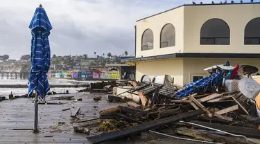 Puing-puing badai didorong ke atas Tacos Morenos di Capitola, California, Kamis (5/1/2023). Angin topan yang merusak, ombak bergelombang dan hujan lebat dari "sungai atmosfer" yang kuat menghantam California pada hari Kamis, melumpuhkan listrik hingga puluhan ribu, menyebabkan banjir, dan mengakibatkan kematian setidaknya dua orang, termasuk seorang anak yang rumahnya dihantam pohon tumbang. (AP Photo/Nic Coury)