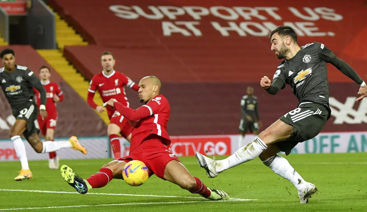 Gelandang Liverpool, Fabinho, berusaha menghalau tendangan pemain Manchester United, Bruno Fernandes, pada laga Liga Inggris di Stadion Anfield, Minggu (17/1/2021). Kedua tim bermain imbang 0-0. (Michael Regan/Pool via AP)