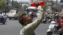 Seorang pria menyiramkan air ke wajahnya saat musim panas di Hyderabad, India, Sabtu, 14 Mei 2022. Suhu di New Delhi mencapai 45 Derajat Celcius. (AP Photo/Mahesh Kumar A.)